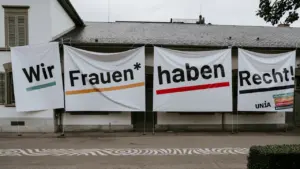 Transparente mit der Aufschrift Wir Frauen haben Recht hängen an einem historischen Gebäude.