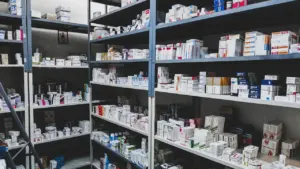 Ein gefülltes Regal mit verschiedenen Medikamenten in einer Apotheke oder Praxis.