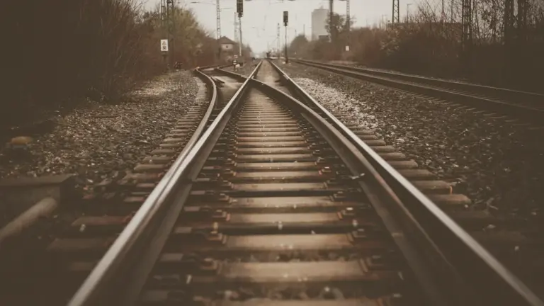 Blick auf eine Eisenbahnschiene in Deutschland mit Oberleitungen im Hintergrund.