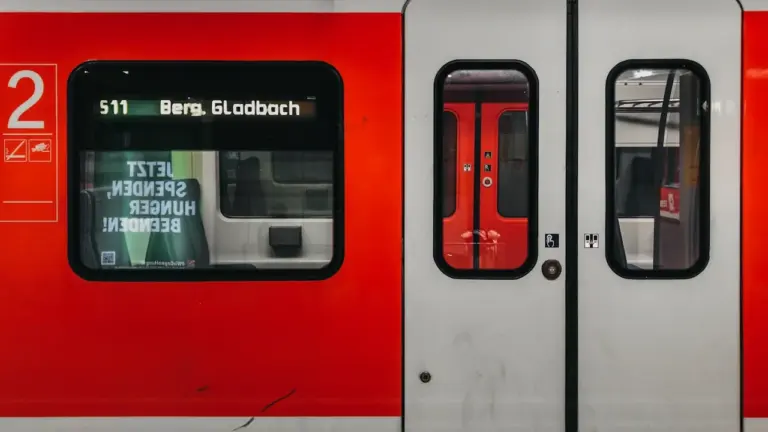 Nahaufnahme eines roten Regionalzuges mit Anzeige nach Bergisch Gladbach am Bahnsteig.