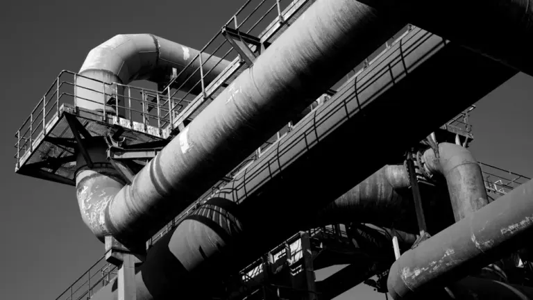 Schwarz-Weiß-Aufnahme von industriellen Rohrleitungen im Landschaftspark Nord in Duisburg.