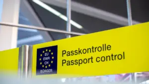 Gelbes Schild mit der Aufschrift Passkontrolle an einem europäischen Flughafen.