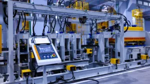 Industrielle Fertigungsanlage mit Steuerpult in einer modernen Produktionshalle für Elektrogeräte.