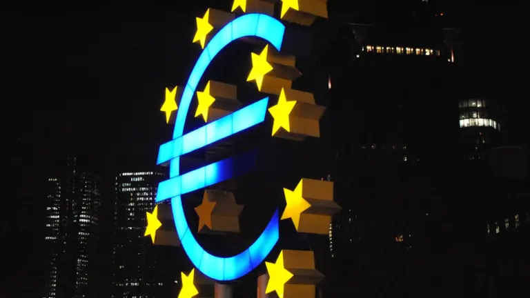 Das leuchtende Euro-Symbol bei Nacht vor einem Bürogebäude in Frankfurt am Main.