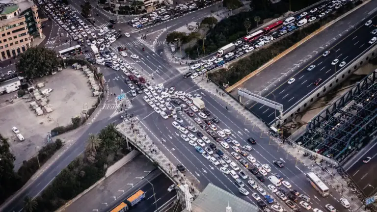 Draufsicht auf einen dichten Stau an einer großen Straßenkreuzung bei Tag.