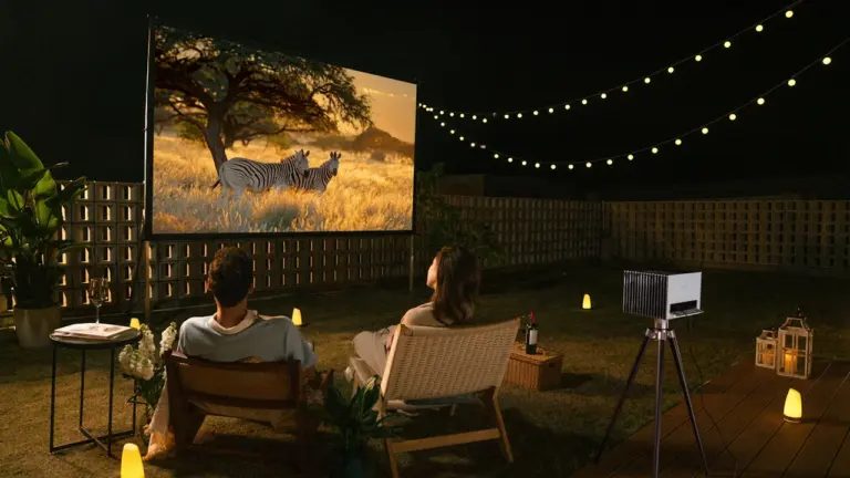 Paar genießt einen entspannten Filmabend im eigenen Garten bei sommerlicher Atmosphäre.