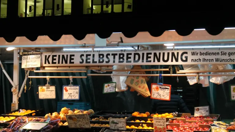 Obststand auf einem deutschen Markt mit einer Warnung vor Selbstbedienung