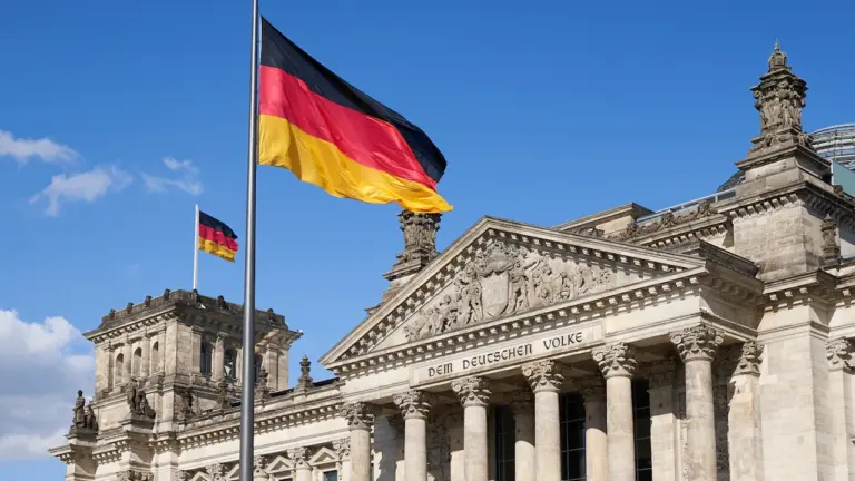 Die deutsche Flagge weht vor dem historischen Reichstagsgebäude in Berlin.