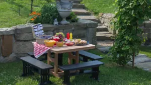 Ein gedeckter Picknicktisch im Freien mit Speisen in einem sommerlichen Garten.