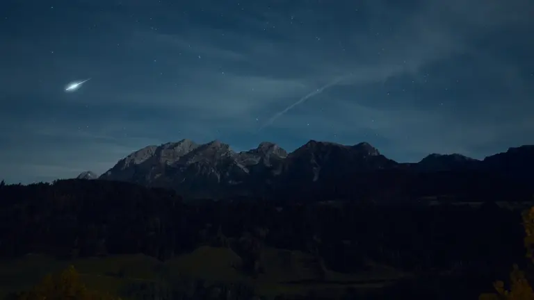 Sternenhimmel mit Mond über einer malerischen bayerischen Bergkette in der Nacht.