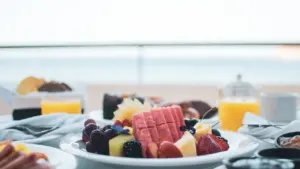 Ein reichhaltiges Frühstück mit frischem Obst und Getränken an Bord eines Schiffes.