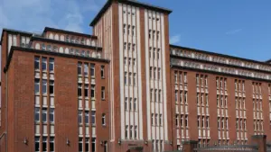 Ein großes, repräsentatives Backsteingebäude in Hamburg, das an eine Schule erinnern könnte.