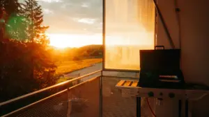 Ein Balkon mit Grill in der warmen Beleuchtung der goldenen Abendsonne.