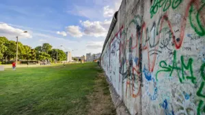 Die Berliner Mauer mit Graffiti und Grünfläche als stummes Zeugnis der deutschen Teilung.
