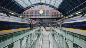 Ein Bahnhof mit Zügen und einer großen Bahnhofsuhr im Hintergrund.