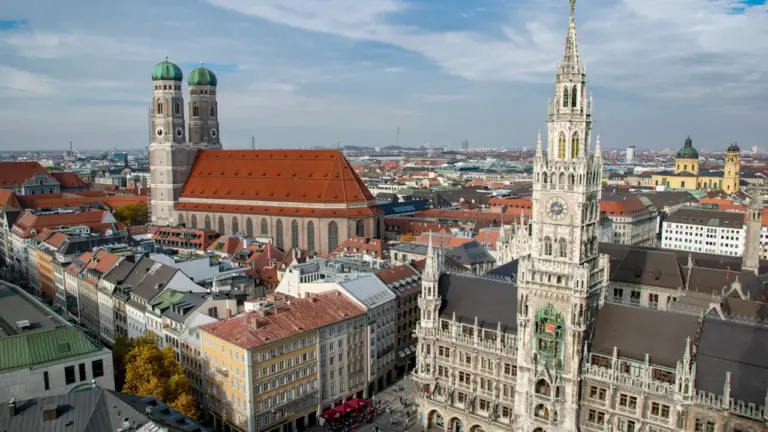 Luftaufnahme des historischen Marienplatzes im Zentrum von München bei strahlendem Sonnenschein.