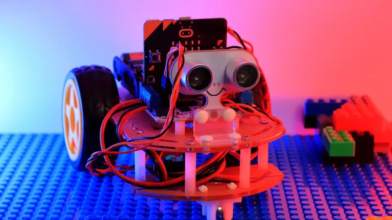 Ein kleiner, selbstgebauter Roboter mit Sensoren steht auf einer blauen Lego-Platte.