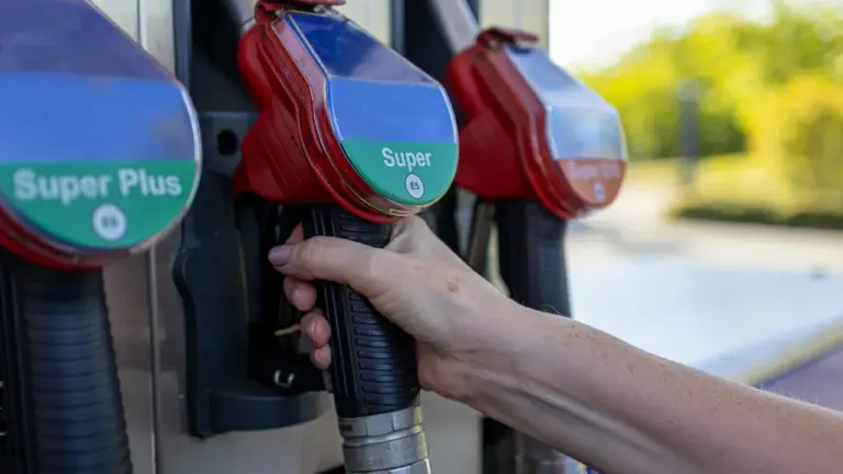 Nahaufnahme einer Hand an einer Zapfpistole an einer modernen Tankstelle