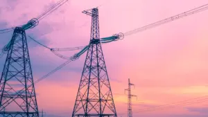 Hochspannungsmasten vor einem dramatischen Sonnenuntergang symbolisieren die Herausforderungen der Energiewende in Deutschland.