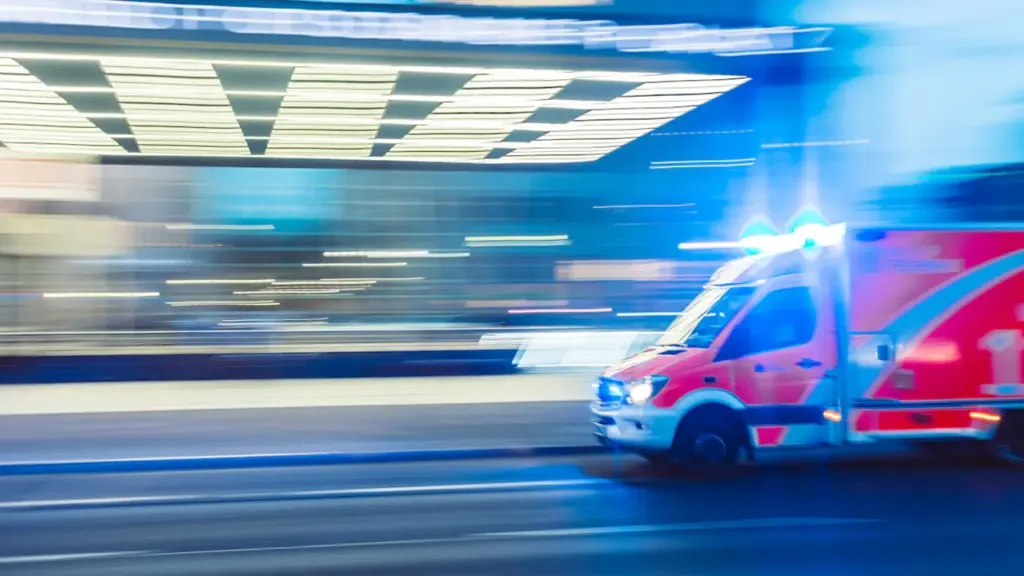 Ein Rettungswagen fährt mit Blaulicht bei Nacht durch die Stadt.