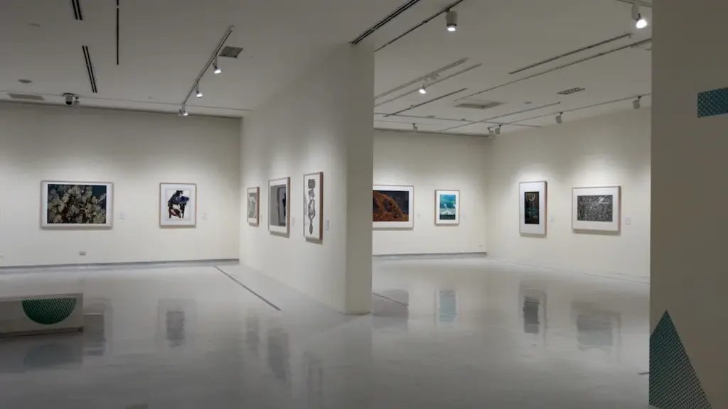 Eine moderne Kunstgalerie mit zahlreichen gerahmten Grafiken an den weißen Wänden.